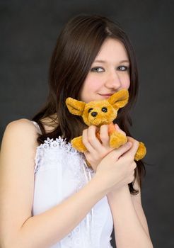 Portrait of teenage girl with a favorite toy on black