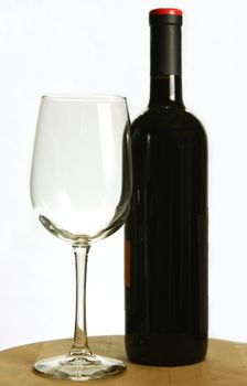 Bottle of red wine and single wine glass, isolated