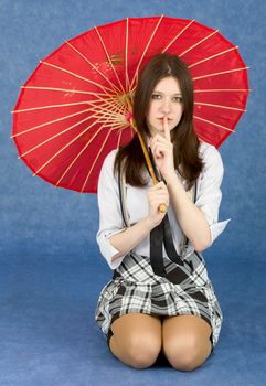 Girl with a red oriental umbrella on a blue background