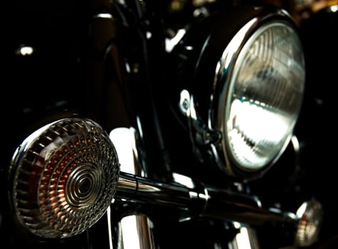 Chromed motorcycle headlights and turns on black background