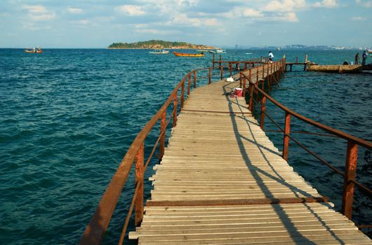 Old wooden pier, bright sea vessel on the horizon, best place for tourism.