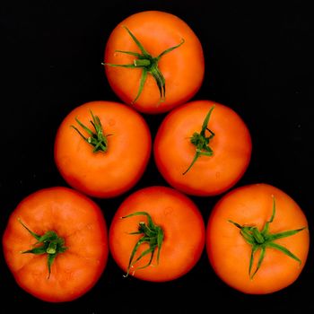 fresh red tomatoes on a black background