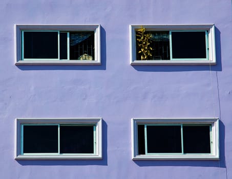 Artistic background. Windows on the purple wall with clear and right colors.