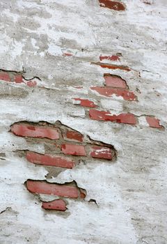 Fragment of old brick wall with white stucco