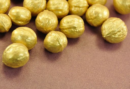 Lot of Golden Nuts on Brown Background, Close-Up