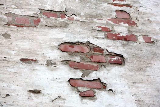 Fragment of old brick wall with white stucco