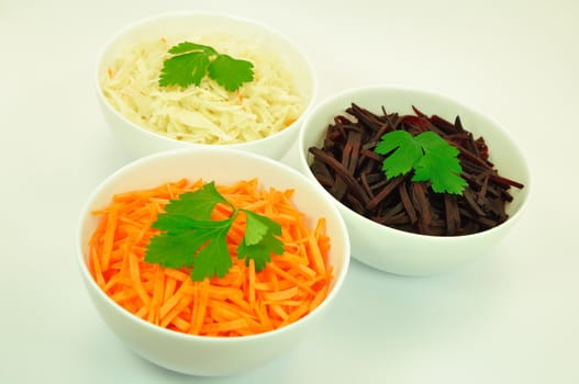 Salads of Carrot, Sauerkraut and Beetroot in White Bowls Isolated