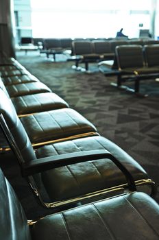 Row of chairs and escalator inside an airport