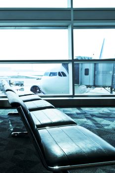 Waiting area of airport gate with airplane outside