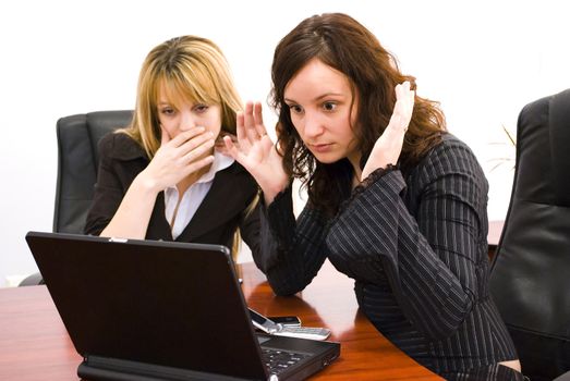 two surprised young businesswomen looking at the computer