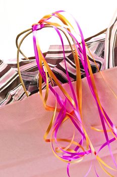 Pink shopping bag with ribbons isolated on white background