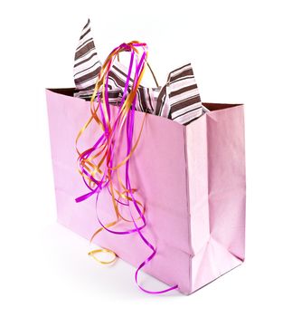 Pink shopping bag with ribbons isolated on white background