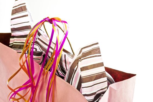 Pink shopping bag with ribbons isolated on white background