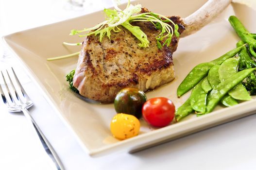 Gourmet dinner of veal rib chop and vegetables