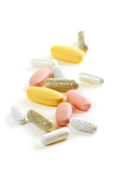 Mix of vitamins and herbal supplements on white background