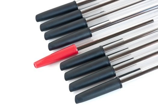 group of black pens with a red one isolated on white background 