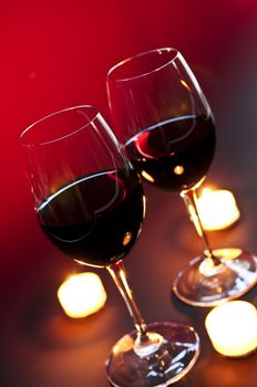 Two wineglasses with red wine at candlelight
