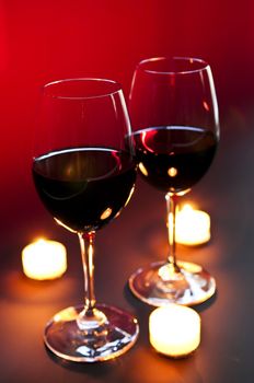 Two wineglasses with red wine at candlelight