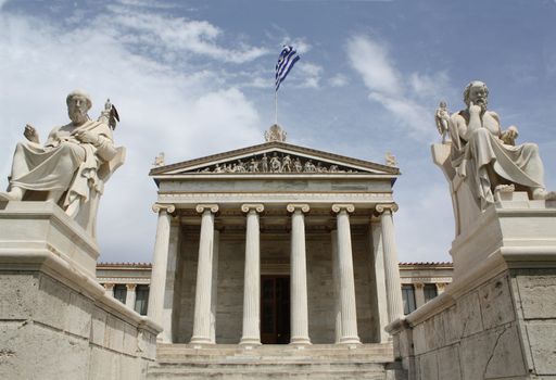 Neoclassical Academy of Athens in Greece showing main building and statues of ancient Greek philosopers Plato (left) and Socrates (right). The statues of goddess Pallas Athena and god Apollo are behind. The Academy of Athens is the highest research establishment in the country and one of the major landmarks of the city.