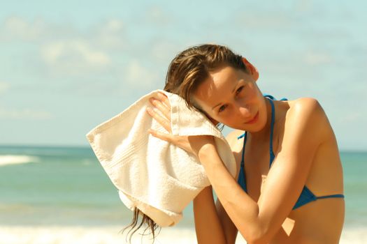 Jung woman drying her hair on the beach