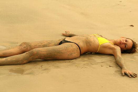 bikini girl lying on the beach by sunset