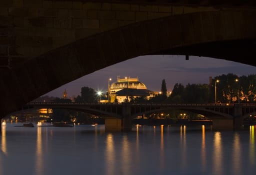 city centre of Prague by night - observed through a bridge arch