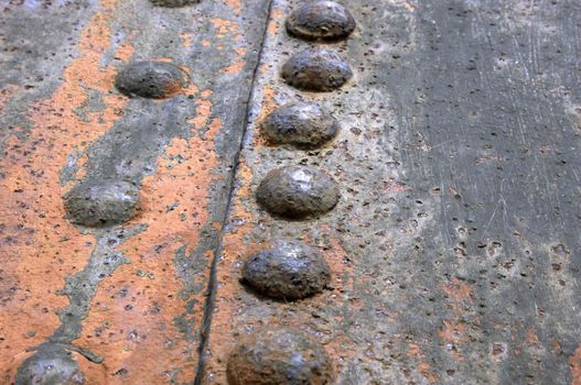 Rivets on rusty metal sheet