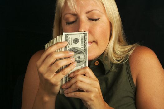 Attractive Woman Enjoys the Smell of Her Stack of Money