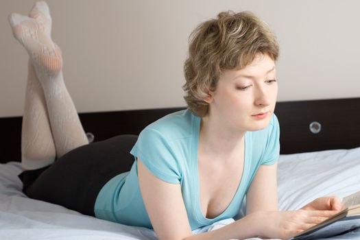 young woman reading book on a bed, shallow DOF, focus on eyes