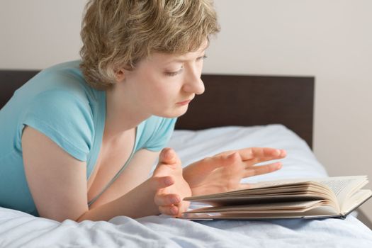 young woman reading book on a bed, shallow DOF, focus on eyes