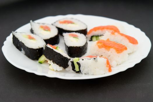 japanese sushi on a white plate on a black background
