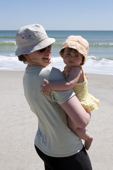 Mother and young daughter enjoying summer at the beach.