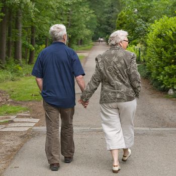 outside portrait of an elderly couple walking along a forest road