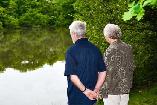outside portrait of an elderly couple standing near a lake