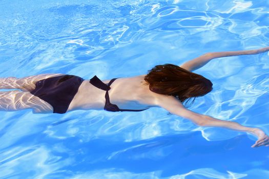 woman diving in the blue swimming pool