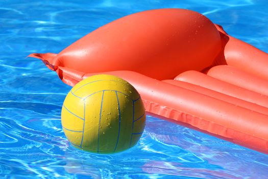 inflatable mattress and ball swimming in the pool