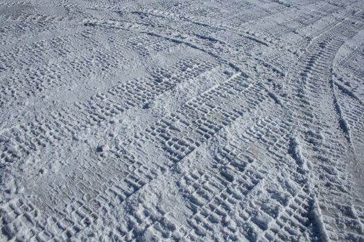 Car tracks crossing the winter terrain in different directions.