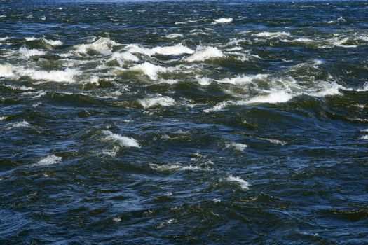 Waves splashing in a river. Water surface texture.