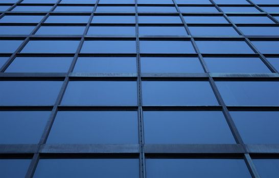 Blue glass panels of a skyscraper, perspective view.