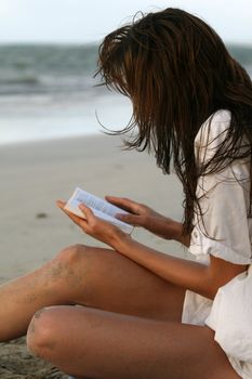 Young women reading book on the beach