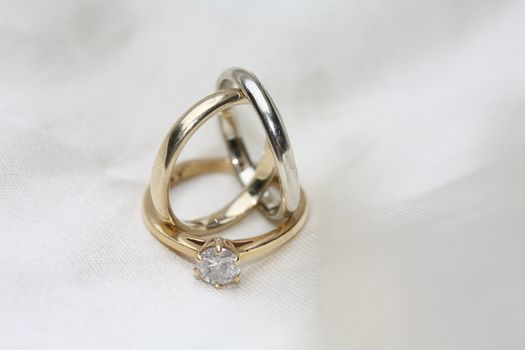 two simple plain wedding bands and a diamond solitaire engagement ring