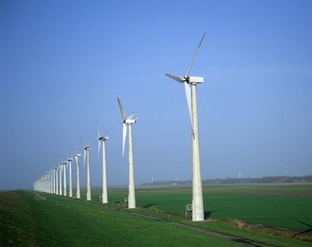 Modern windmills in a line at a windpark in the Netherlands.