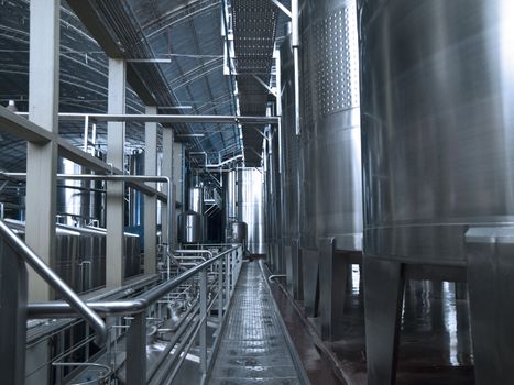 Stainless steel wine vats in a row inside the winery.