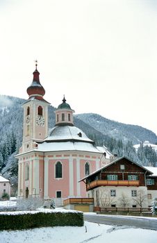 A small rural church is dusted with snow in the Austrian Alps