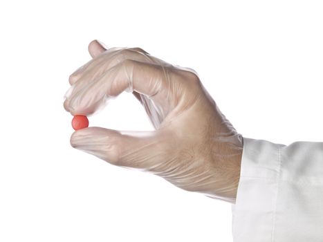 A doctor holds a red pill with his latex gloves on. Isolated on white.