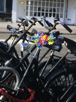 A group of bicycles, one with a flowered chain, in Amsterdam, the Netherlands- bikes are an environmantally friendly mode of urban transportation