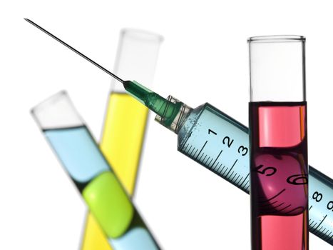 A syringe and three test tubes filled with colored liquids. Isolated on white.