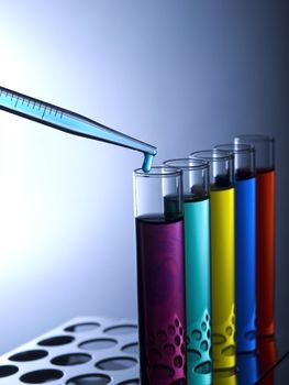 Close up of test tubes filled with color liquids and a pipette.