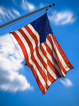 An american flag waving over a blue sky. Zooming effect.