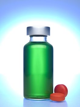 Close up of a vial full of green liquid, red pills aside.